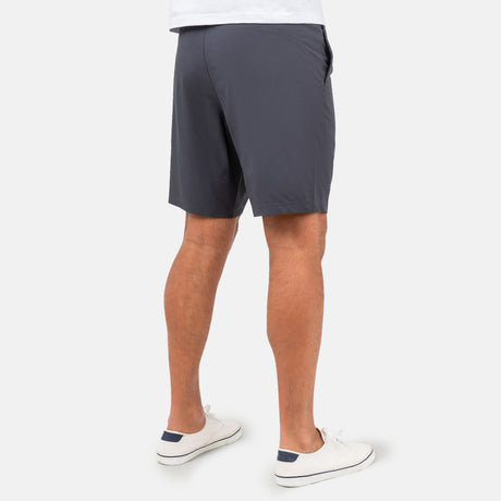 [Model is wearing a size Medium.] Man wearing Free Country Men's Tech Stretch Short II in Charcoal, size M, made from moisture wicking stretch performance fabric featuring an elastic waistband with a drawcord and a side slant pockets, styled with a white t shirt #color_charcoal