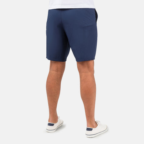 [Model is wearing a size Medium.] Man wearing Free Country Men's Tech Stretch Short II in Slate, size M, made from moisture wicking stretch performance fabric featuring an elastic waistband with a drawcord and a side slant pockets, styled with a white t shirt #color_slate