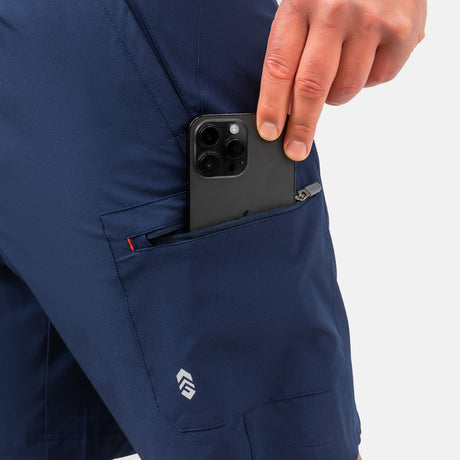[Model is wearing a size Medium.] Man wearing Free Country Men's Tech Stretch Short II in Slate, size M, made from moisture wicking stretch performance fabric featuring an elastic waistband with a drawcord and a side zipper pocket, styled with a white t shirt #color_slate