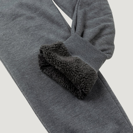 A close-up of Clearance Men's Sherpa Lined Jogger reveals its soft black sherpa lining inside the sleeve and pants leg, emphasizing warmth and comfort—ideal for athleisure wear.
