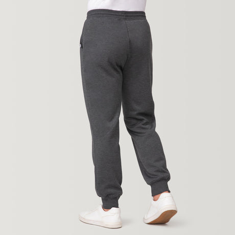 [Model is 6'1" wearing a size Medium.] Man wearing Free Country Men's Sherpa Lined Jogger in dark grey with a drawcord waistband, soft lining, and side pockets, light grey background. Perfect men’s pants for fall weather.