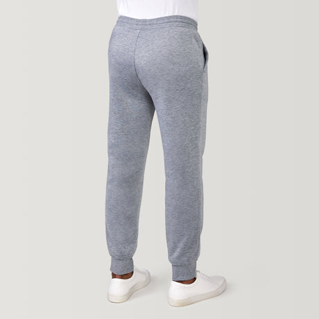 [Model is 6'1" wearing a size Medium.] Man wearing Free Country Men's Sherpa Lined Jogger in light grey with a drawcord waistband, soft lining, and side pockets, light grey background. Perfect men’s pants for fall weather.