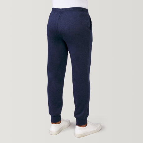 [Model is 6'1" wearing a size Medium.] Man wearing Free Country Men's Sherpa Lined Jogger in dark navy with a drawcord waistband, soft lining, and side pockets, light grey background. Perfect men’s pants for fall weather.