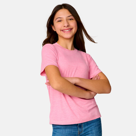 [Model is wearing a size Medium.] Girl  wearing the Free Country Girls’ Microtech® Crew Neck Shirt in Pink, size M, featuring lightweight odor free fabric and upf protection, paired with blue jeans #color_ pink