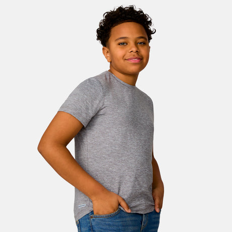 [Model is wearing a size Medium.] Boy wearing the Free Country Boys' Microtech® Crew Neck Shirt in Rock, size M, featuring lightweight odor free fabric and upf protection, paired with blue jeans #color_ rock