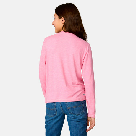 A person with long brown hair, wearing a Clearance Girls' Microtech® Long Sleeve Shirt in light pink and blue jeans, stands facing away from the camera against a plain light background.
