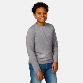 [Model is wearing a size Medium.] Boy wearing the Free Country Boys' Microtech® Long Sleeve Shirt in Rock, size M, featuring lightweight odor free fabric and upf protection, paired with blue jeans #color_ rock