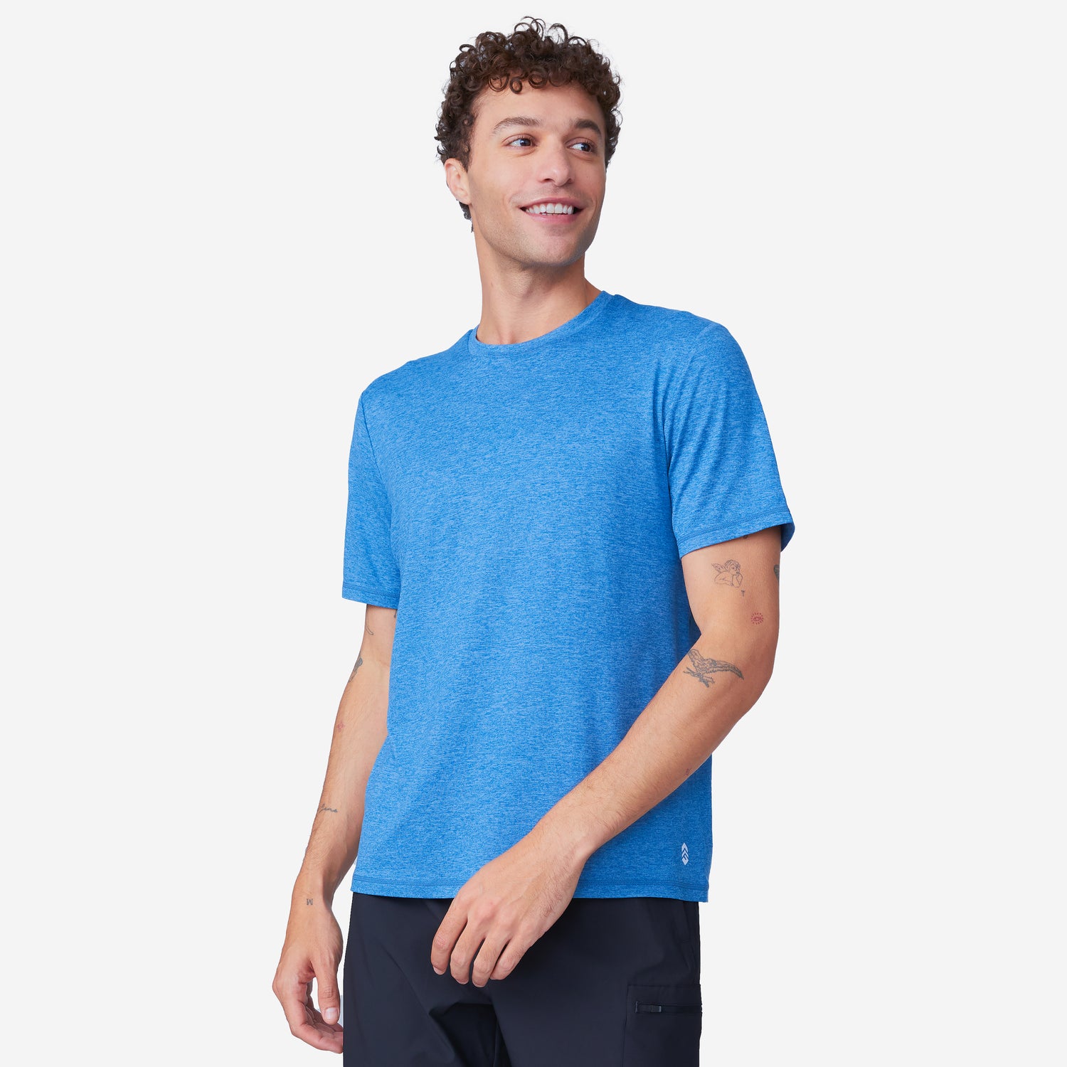 A man wearing a blue Men’s Super Soft Microtech® Short Sleeve Crew Tee and black four-way stretch shorts.