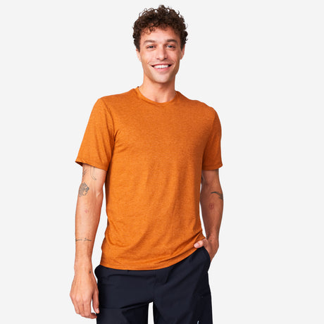 A smiling man wearing a caramel-colored Men’s Super Soft Microtech® Short Sleeve Crew Tee and dark shorts.