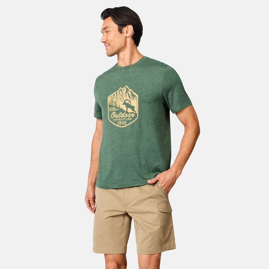 [Scott is 6’3" wearing size M] Man wearing a green t-shirt with a logo and beige shorts on a white background