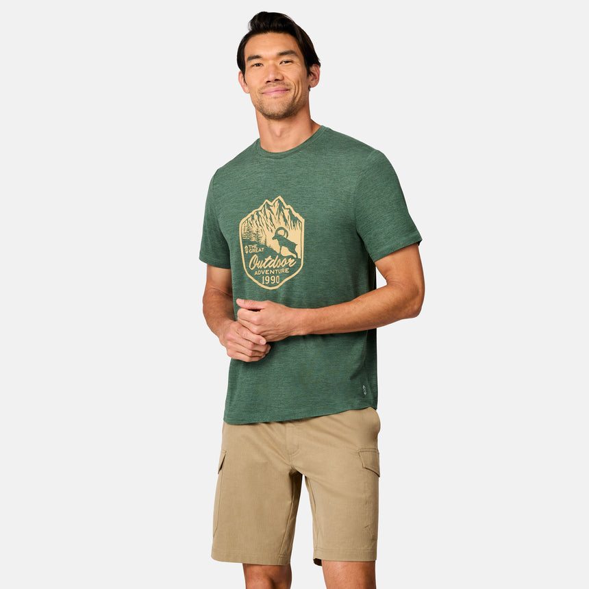 [Scott is 6’3" wearing size M] Man wearing a green t-shirt with a logo and beige shorts on a white background