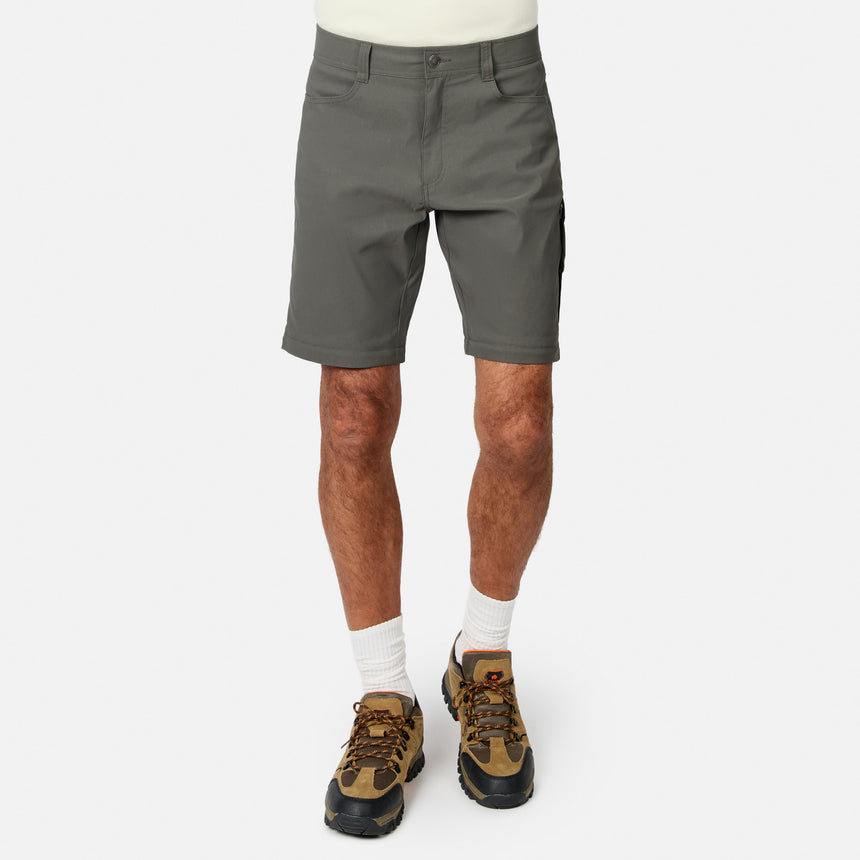 A person wears Free Country Men’s Nylon Stretch Convertible Pant in gray, white socks, and brown hiking shoes, standing against a white background. The image is cropped at the waist and just below the knees.