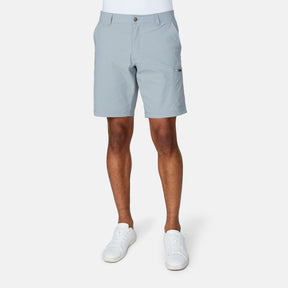 [Josiah is 6'3" wearing a size Medium.] Man wearing Free Country Men's Nylon Stretch Casual Short in Iron, size M, made from lightweight stretch performance fabric featuring a water repellent finish, slanted side pockets, and side leg zippered coin pocket, styled with a white t shirt and white shoes #color_iron