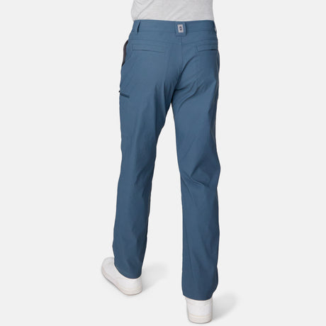 [Miguel is 6'2" wearing a size Medium.] Man wearing Free Country Men's Nylon Stretch Casual Pant in Seal, size M, made from comfortable stretch performance fabric featuring a water repellent finish, articulated knee, coin pocket, and gusset at crotch, styled with a white t shirt and white shoes #color_seal