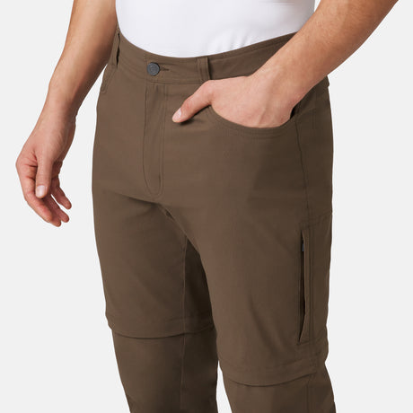 [Model is wearing a size Medium.] Man wearing Men's Nylon Stretch Convertible Pant in Saddle, size M, made from lightweight stretch performance fabric featuring a water repellent finish, an elastic waistband, above knee removable pants legs, and two side sipper pockets, styled with a grey t shirt and white shoes #color_saddle