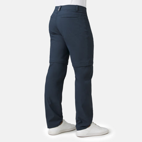 [Model is wearing a size Medium.] Man wearing Men's Nylon Stretch Convertible Pant in Steel, size M, made from lightweight stretch performance fabric featuring a water repellent finish, an elastic waistband, above knee removable pants legs, and two side sipper pockets, styled with a grey t shirt and white shoes #color_steel