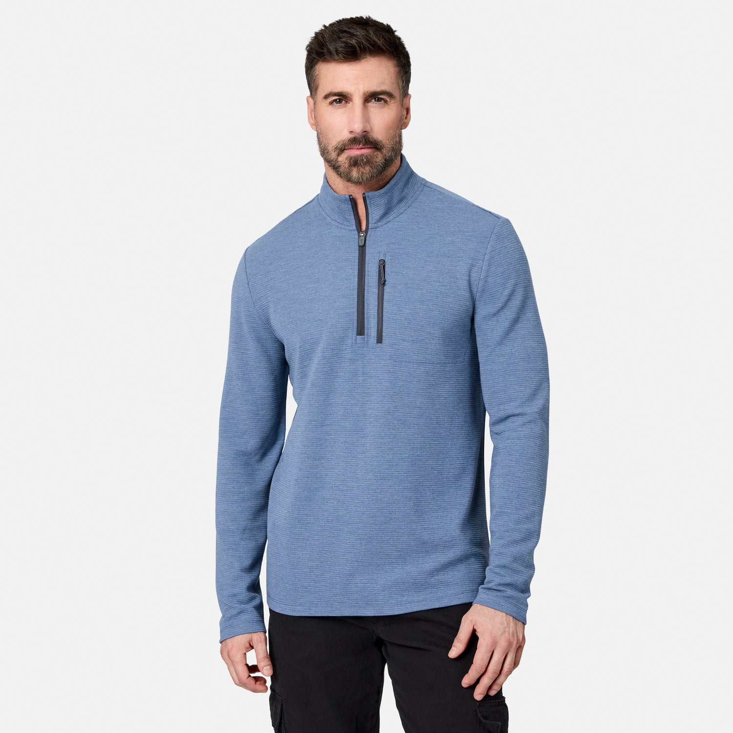 A man with dark hair and a beard wears the Men’s Altitude Quilt 1/2 Zip Mock Neck Shirt by Free Country in Ocean Heather, which features 4-way stretch and a chest pocket, standing against a plain white background.