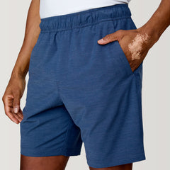[Anderson is 6'2" wearing a size Medium.]  Man wearing the Free Country Men's Boardwalk Woven Pull-On Trek Short in Denim, size M, made from lightweight breathable polyester fabric and featuring an elastic waistband and slanted pockets, styled with a white t shirt #color_ denim