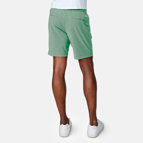 [Anderson is 6'2" wearing a size Medium.]  Man wearing the Free Country Men's Boardwalk Woven Pull-On Trek Short in Basil, size M, made from lightweight breathable polyester fabric and featuring an elastic waistband and slanted pockets, styled with a white t shirt #color_ basil
