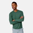 [Anderson is 6'2" wearing a size Medium.] Man wearing Free Country Men's Henley Long Sleeve Shirt in Cilantro, size M, made from lightweight soft polyester fabric featuring a classic fit with anti odor and upf technology, styled with grey shorts #color_cilantro