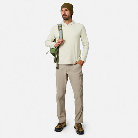 [Model is wearing size M.] A man modeling a light beige hooded long-sleeve shirt, khaki pants, brown hiking boots, and an olive green beanie, carrying a green backpack strap against a light gray studio background.