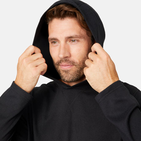 [Matt is 6'2" wearing size M.] Free Country men’s dark-colored hooded long-sleeve shirt with relaxed fit—styled with blue pants against a plain white background for a casual, comfort-forward look.
