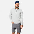 A man wears the Free Country Men’s Twill Interlock 1/4 Zip Long Sleeve Shirt in Grey Heather, paired with gray shorts and a navy blue beanie, standing against a plain white background.