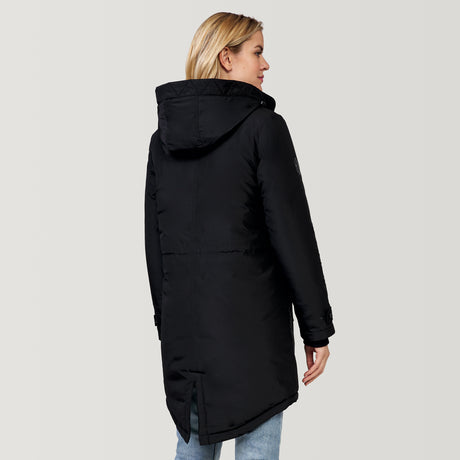 A person in the Clearance Women's Arctic Anorak Jacket, a long black hooded coat with REPREVE fill and a back slit, faces away. They pair it with light blue jeans, set against a plain light gray background.