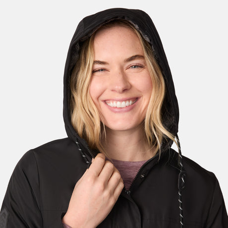 [CJ is 5'10" wearing size S.] Women’s black hooded rain jacket with front zipper and snap button closure, flap pockets, and adjustable waist drawstring—styled with blue jeans for a casual, weather-ready look.