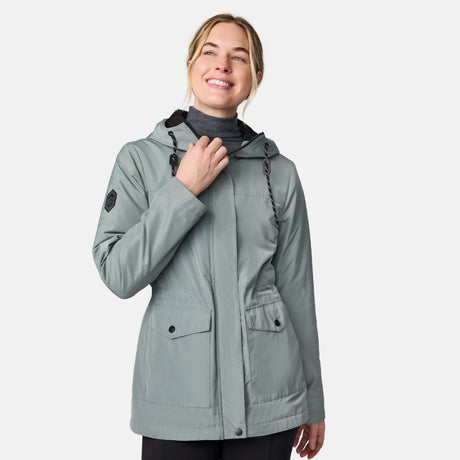 [CJ is 5'10" wearing size S.] Women’s light green hooded rain jacket with front zip closure, flap pockets with button accents, black hood drawstrings, and a sleeve patch—layered over a dark gray turtleneck and styled with black pants for a sleek, weather-ready look.