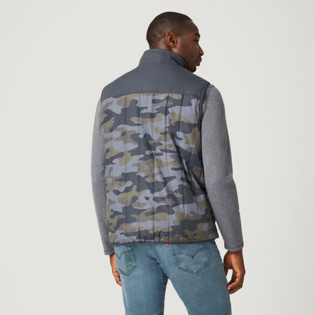 A man stands with his back to the camera on a white background, wearing blue jeans, a gray long-sleeve shirt, and the Clearance Men's FreeCycle® Alpine Reversible Vest.