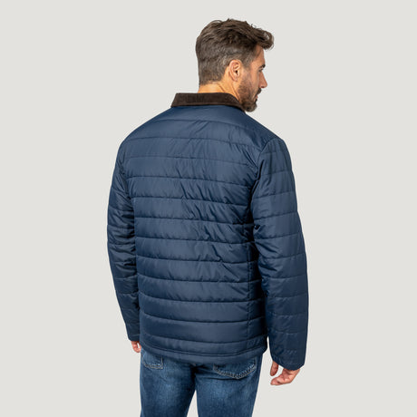 [Model is wearing size M.] A man shown from the back wearing a navy blue quilted puffer jacket with a brown corduroy collar, paired with blue jeans, against a solid light gray background.