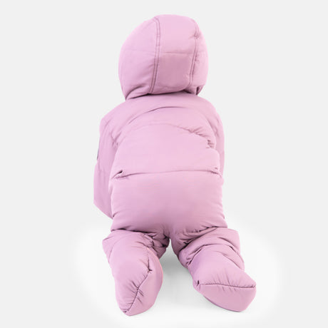 A baby is crawling on a white surface, shown from the back, wearing the Clearance Kids' Out of Bound Puffer Snow Suit—a thick, sherpa-lined, light purple hooded snowsuit.
