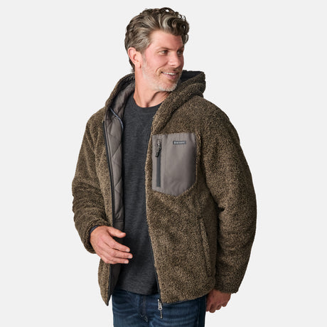 [Kolby is 6'2" wearing size M.] Men’s Free Country grey quilted hooded jacket with full-zip closure, adjustable drawstring hood, and dual hand pockets—reversible to a plush sherpa lining for enhanced warmth and cozy comfort. Styled over a dark crewneck and jeans for an effortlessly rugged, cold-weather vibe.