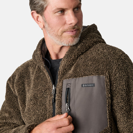 [Kolby is 6'2" wearing size M.] Men’s Free Country grey quilted hooded jacket with full-zip closure, adjustable drawstring hood, and dual hand pockets—reversible to a plush sherpa lining for enhanced warmth and cozy comfort. Styled over a dark crewneck and jeans for an effortlessly rugged, cold-weather vibe.