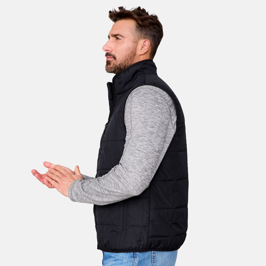 [Justin is 6'1" wearing size M.] Men’s Free Country black quilted vest with zip-front closure and stand collar—layered over a gray long-sleeve shirt and blue jeans. Designed for lightweight warmth and styled for transitional weather versatility.