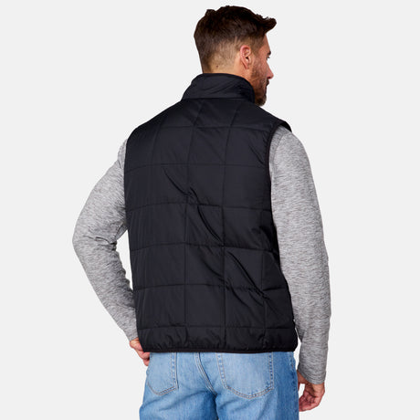 [Justin is 6'1" wearing size M.] Men’s Free Country black quilted vest with zip-front closure and stand collar—layered over a gray long-sleeve shirt and blue jeans. Designed for lightweight warmth and styled for transitional weather versatility.