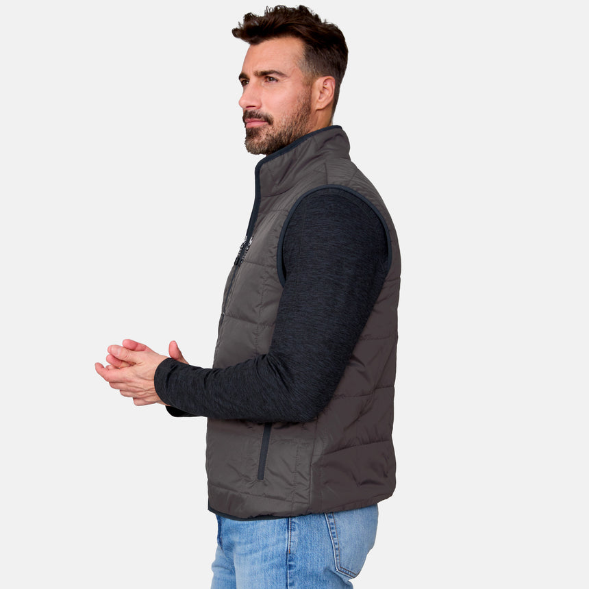 [Justin is 6'1" wearing size M.] Man wearing a dark gray puffer vest over a black long-sleeve shirt on a light gray background