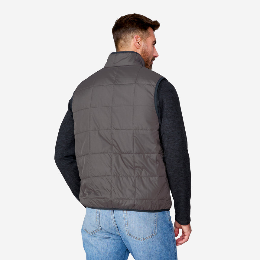 [Justin is 6'1" wearing size M.] Man wearing a gray puffer vest over a black long-sleeve shirt on a white background