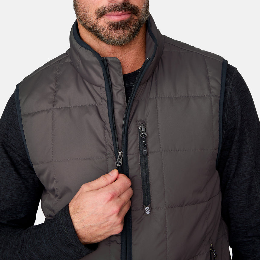 [Justin is 6'1" wearing size M.] Man wearing a gray puffer vest with a black shirt underneath on a white background