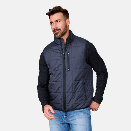 [Justin is 6'1" wearing size M.] Man wearing a navy puffer vest over a black long-sleeve shirt on a light gray background