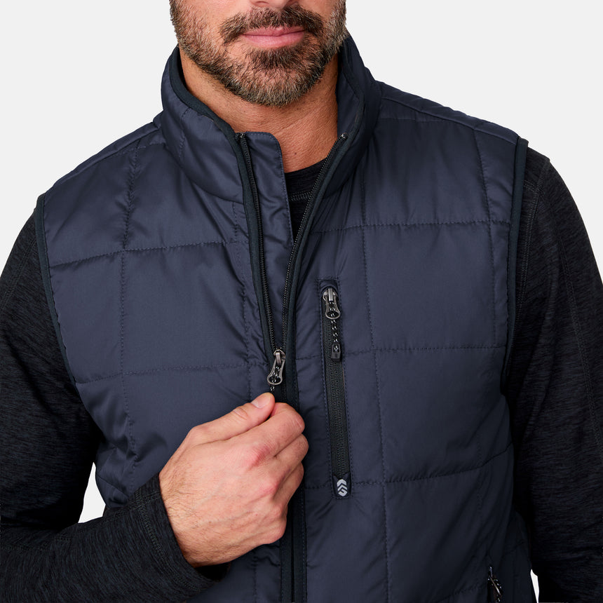 [Justin is 6'1" wearing size M.] Man wearing a navy puffer vest on a plain background