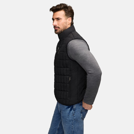 Side profile of a man wearing a black Sperrin full zip puffer vest over a gray long sleeve shirt