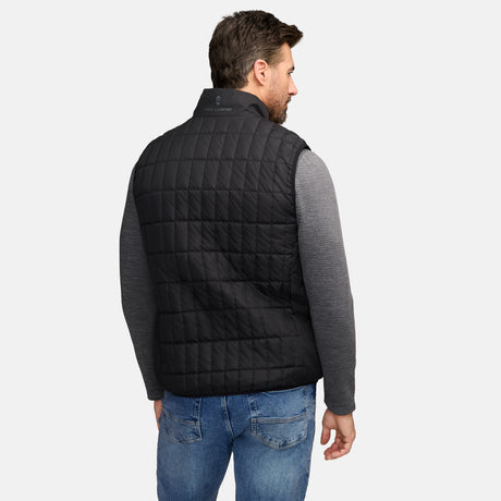 Back view of man in black quilted puffer vest with Free Country logo on collar