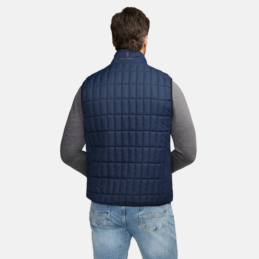 Back view of navy quilted Sperrin puffer vest with a collar logo, worn over a grey top and jeans.
