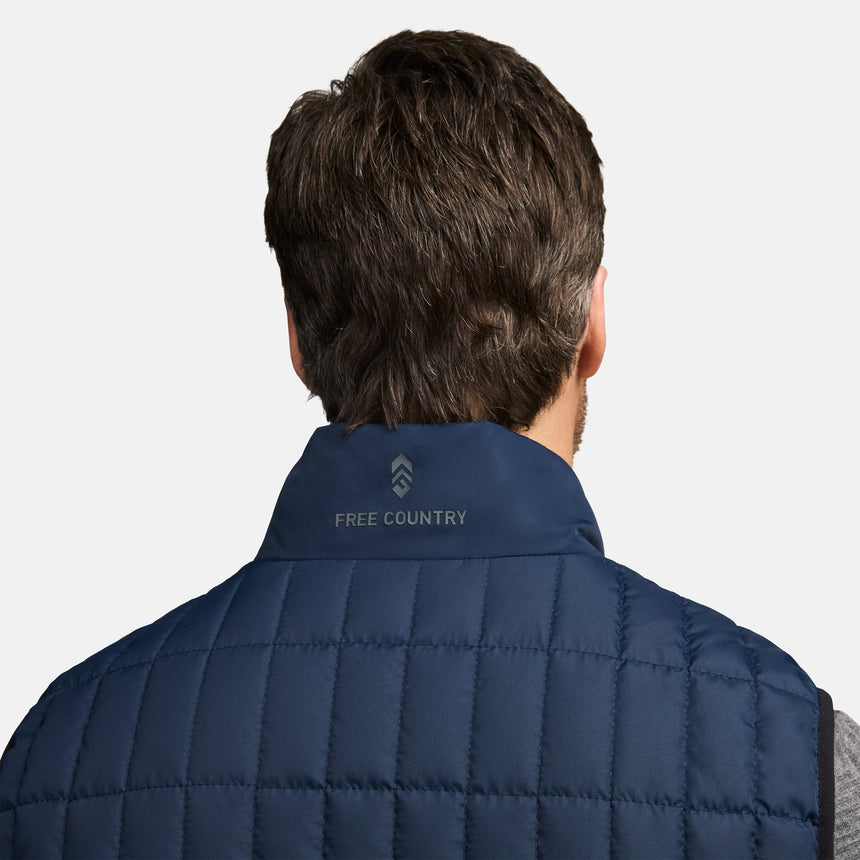 Back view of navy Sperrin full zip puffer vest on a person, with short dark hair and a collar logo.