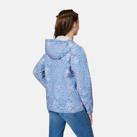 A girl with brown hair faces away from the camera, modeling the Free Country Girls' Recess X2O Rain Jacket in light blue, purple, and pink patterns with blue jeans against a plain white background.