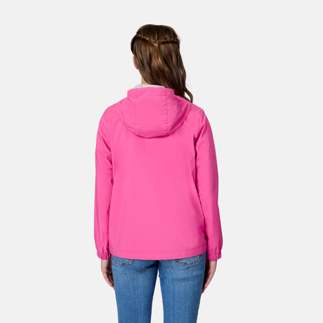 A girl with long brown hair in a braid is seen from behind wearing the Free Country Girls' Recess X2O Rain Jacket in bright pink and blue jeans, set against a plain white background.