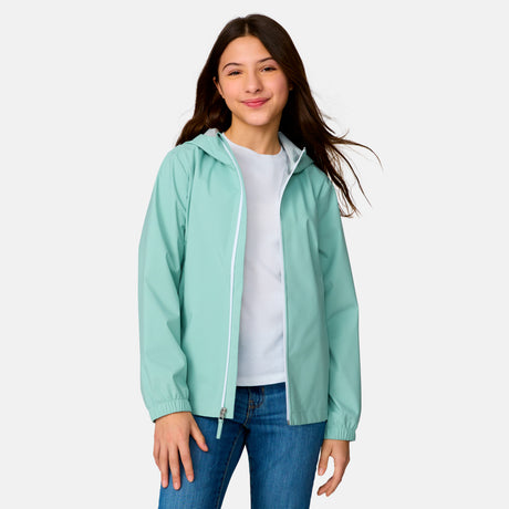 [Model is wearing a size Medium.] Girl wearing the Free Country Girls' Recess X2O Rain Jacket in Green Tea, size M, featuring lightweight stretch weatherproof fabric and a full length zipper and attached hood, paired with blue jeans #color_ green-tea