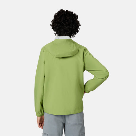 A person with curly hair faces away, wearing the Free Country Boys' Hydro Lite Recess X2O Rain Jacket in light green and light gray cargo pants against a plain, light background.